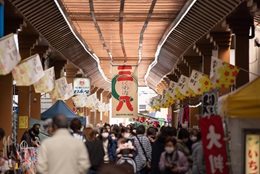 くわな寺町商店街の風景。大きなアーケード屋根の通りに多くの人が歩いている